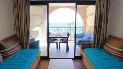 a room with two beds and a table and a balcony at Appartement 616, 5 personnes belle vue Mer By Palmazur Vacances in Cannes