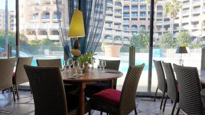 a dining room with a table and chairs and a large window at Appartement 616, 5 personnes belle vue Mer By Palmazur Vacances in Cannes