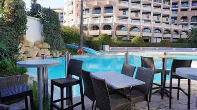 a row of tables and chairs next to a swimming pool at Appartement 616, 5 personnes belle vue Mer By Palmazur Vacances in Cannes