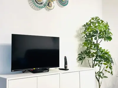 a flat screen tv sitting on top of a white cabinet at Le Cocon - 2 pièces centre Cannes - Terrasse in Cannes