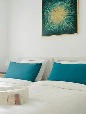 a bedroom with two beds with blue pillows at Le Cocon - 2 pièces centre Cannes - Terrasse in Cannes