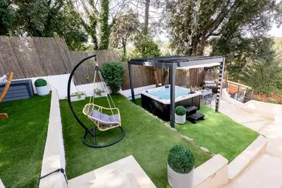 a garden with a swing and a hot tub at Piscine-Jacuzzi-Sauna -Videoprojecteur Perle Rare in Mougins