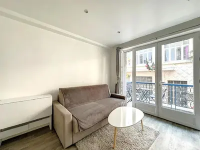 a living room with a couch and a table at Superbe appartement avec terrasse centre-ville et plage à 5 min in Cannes