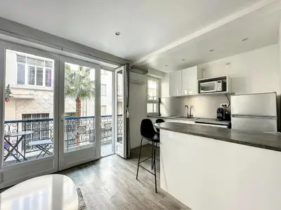 a kitchen with a counter and a large window at Superbe appartement avec terrasse centre-ville et plage à 5 min in Cannes