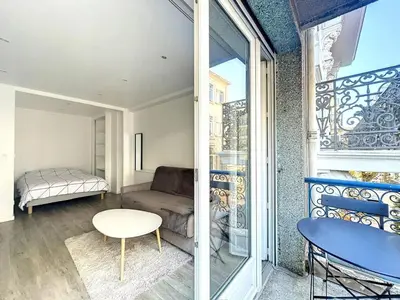 a living room with a couch and a table at Superbe appartement avec terrasse centre-ville et plage à 5 min in Cannes