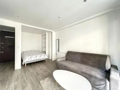 a living room with a couch and a bed at Superbe appartement avec terrasse centre-ville et plage à 5 min in Cannes