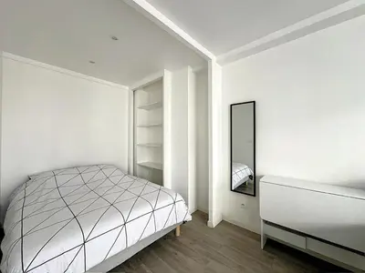 a white bedroom with a bed and a mirror at Superbe appartement avec terrasse centre-ville et plage à 5 min in Cannes