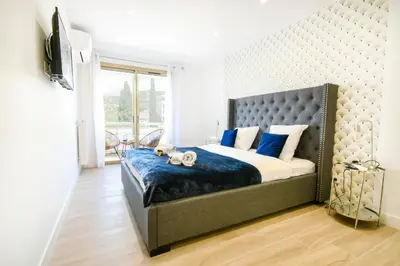 a bedroom with a large bed with blue pillows at Elena YourHostHelper in Cannes