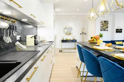 a kitchen with a counter and blue chairs at Elena YourHostHelper in Cannes