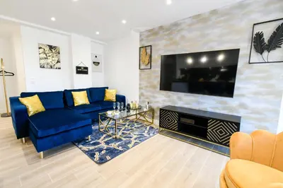 a living room with a blue couch and a tv at Elena YourHostHelper in Cannes