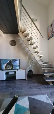 a living room with a tv and a staircase at Joli Duplex cathédrale in Cannes