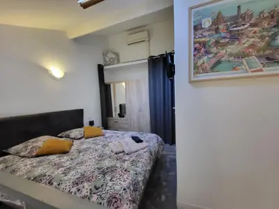 a bedroom with a bed and a painting on the wall at Joli Duplex cathédrale in Cannes