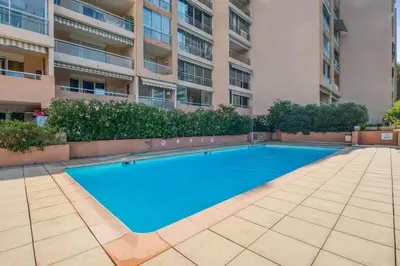 an empty swimming pool in front of a building at Mer et Plage 2 étoiles in Cannes