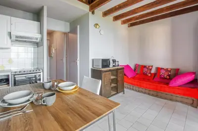 a kitchen and living room with a red couch at Mer et Plage 2 étoiles in Cannes
