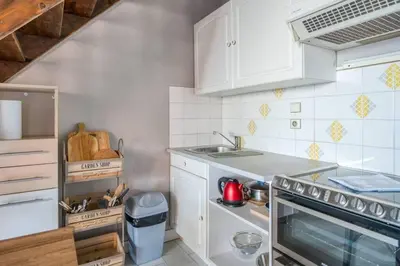 a kitchen with white cabinets and a stove top oven at Mer et Plage 2 étoiles in Cannes