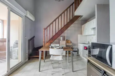 a kitchen with a dining table and a staircase at Mer et Plage 2 étoiles in Cannes
