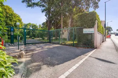a fence with a sign on it next to a street at Mer et Plage 2 étoiles in Cannes