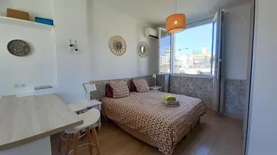 a small bedroom with a bed and a table at Palais Gounod in Cannes