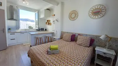 a small bedroom with a bed and a kitchen at Palais Gounod in Cannes