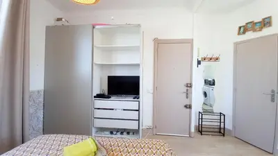 a bedroom with a bed and a dresser with a television at Palais Gounod in Cannes