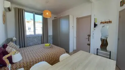 a small apartment with a table and a room with a window at Palais Gounod in Cannes