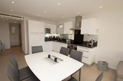 a white kitchen with a white table and chairs at Johnny in Cannes