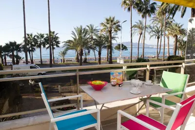 a table and chairs on a balcony with a view of the beach at Johnny in Cannes