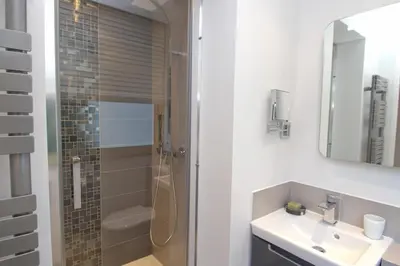 a white bathroom with a shower and a sink at Johnny in Cannes