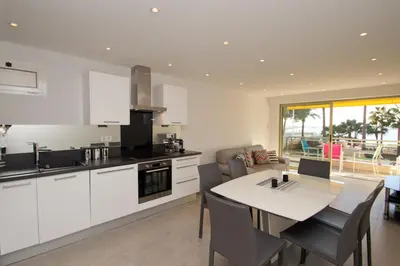 a kitchen with white cabinets and a table and chairs at Johnny in Cannes