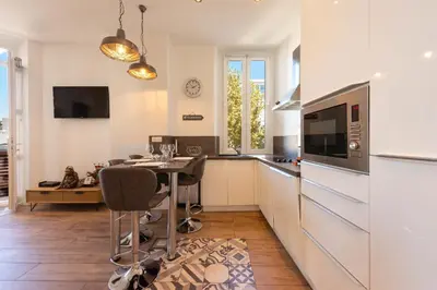 a kitchen with a table with chairs and a microwave at Downtown Cannes walk to Beaches and Croisette in Cannes