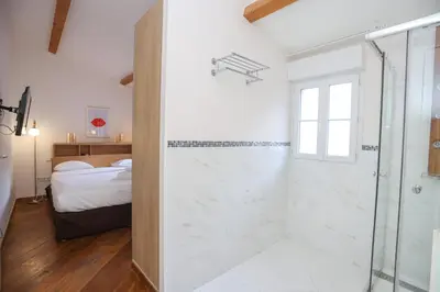 a white bathroom with a shower and a bed at IMMOGROOM - Terrace with sea view - AC - Suquet - 5 min from the beach in Cannes