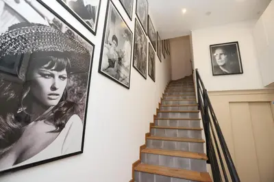 a hallway with pictures on the wall and stairs at IMMOGROOM - Terrace with sea view - AC - Suquet - 5 min from the beach in Cannes