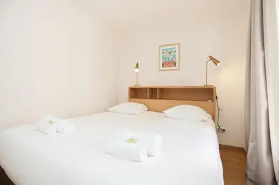 a bedroom with a bed with two towels on it at IMMOGROOM - Beautiful and Cosy - Air conditioner - 5 min from beaches in Cannes