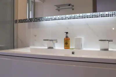 a bathroom sink with a bottle of soap on it at IMMOGROOM - Beautiful and Cosy - Air conditioner - 5 min from beaches in Cannes