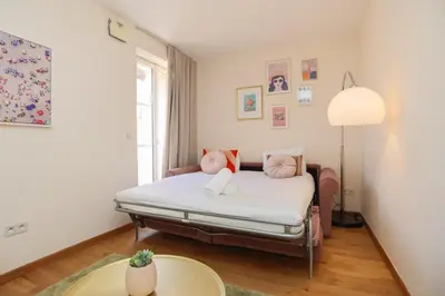 a bedroom with a bed with white sheets and pink pillows at IMMOGROOM - Beautiful and cosy- Suquet- near the beaches - AC in Cannes