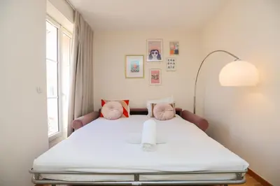 a bedroom with a bed with pink pillows and a window at IMMOGROOM - Beautiful and cosy- Suquet- near the beaches - AC in Cannes