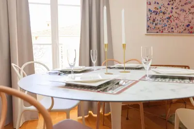a white dining room table with a white tablecloth and glasses at IMMOGROOM - Beautiful and cosy- Suquet- near the beaches - AC in Cannes