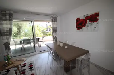 a dining room with a table and a balcony at HSUD0118 Terracotta in Cannes