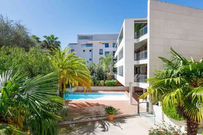 an apartment building with a swimming pool and palm trees at HSUD0118 Terracotta in Cannes