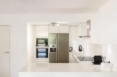 a white kitchen with white cabinets and appliances at HSUD0118 Terracotta in Cannes
