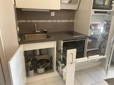 a kitchen with a sink and an open refrigerator at CANNES Appartement Duplex Piscine VUE Mer WIFI PARKING CLIM in Cannes