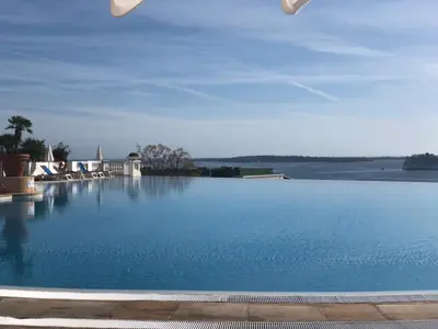a large swimming pool with blue water at CANNES Appartement Duplex Piscine VUE Mer WIFI PARKING CLIM in Cannes