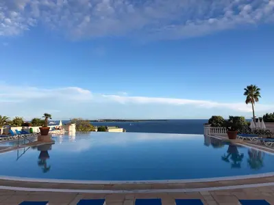 a large swimming pool with a view of the water at CANNES Appartement Duplex Piscine VUE Mer WIFI PARKING CLIM in Cannes