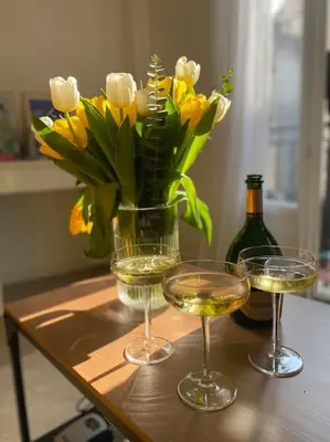 a table with two glasses of wine and a vase of flowers at Maison La Casetta (2ch / 2sdb) - Le Suquet Cannes in Cannes