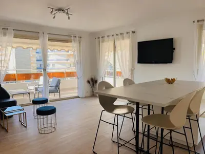 a living room with a dining room table and chairs at le meilleur de Cannes au palm beach in Cannes