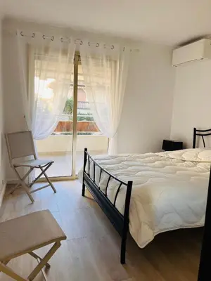 a bedroom with a bed and a large window at le meilleur de Cannes au palm beach in Cannes