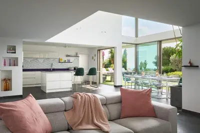a living room with a couch and a kitchen at Cannes - Modern villa with 180° sea view in Vallauris