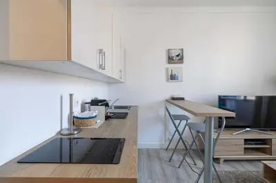a kitchen with a table and a tv and a counter at Beautiful renovated residence near Croisette in Cannes