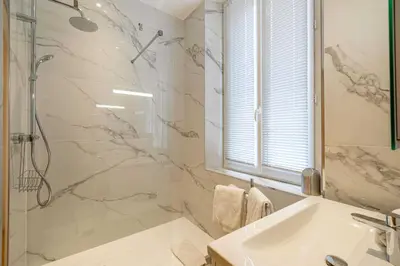a white bathroom with a shower and a sink at Beautiful renovated residence near Croisette in Cannes
