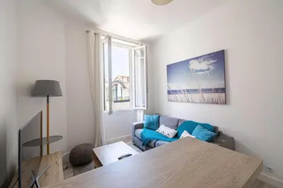 a living room with a blue couch and a table at Beautiful renovated residence near Croisette in Cannes